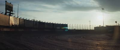 a train traveling down tracks next to a fence