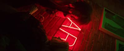 a neon sign sitting on the side of a building
