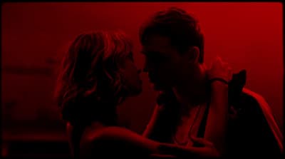 a man and a woman kissing in a dark room