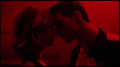 a man and a woman kissing in a red room
