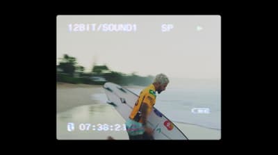 a man holding a surfboard on a beach