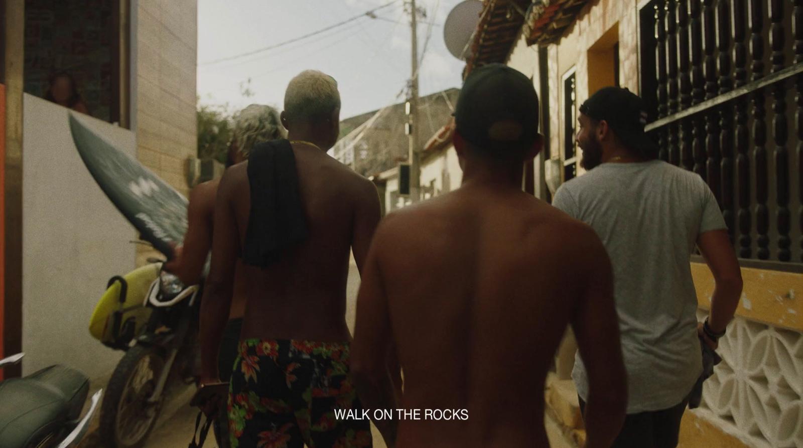 a group of men walking down a street next to a motorcycle
