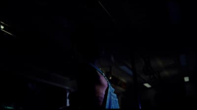 a man standing in a dark room with his back to the camera