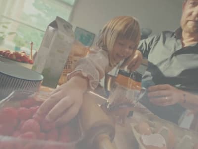 a man and a little girl are making a smoothie