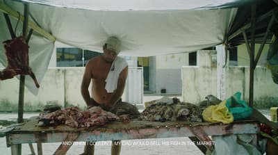 a man standing over a table covered in meat