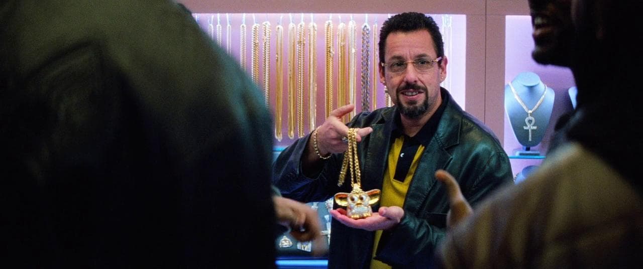 a man in a black leather jacket is holding a necklace