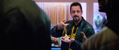 a man in a black leather jacket is holding a necklace