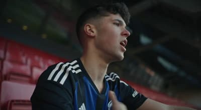 a man in a black and blue shirt playing a game of basketball