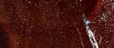 a close up of a red wall with white spots