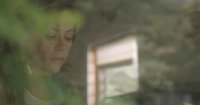 a woman looking down at her cell phone