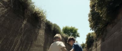 a man and a woman riding a skateboard down a street