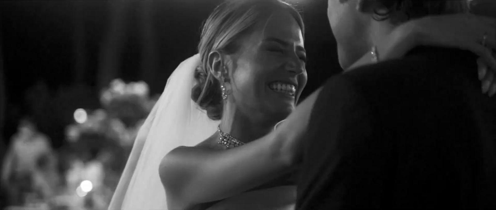a woman in a wedding dress hugging a man