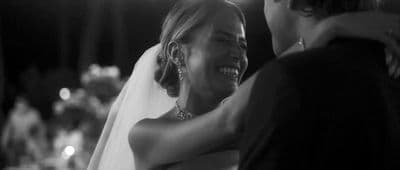 a woman in a wedding dress hugging a man