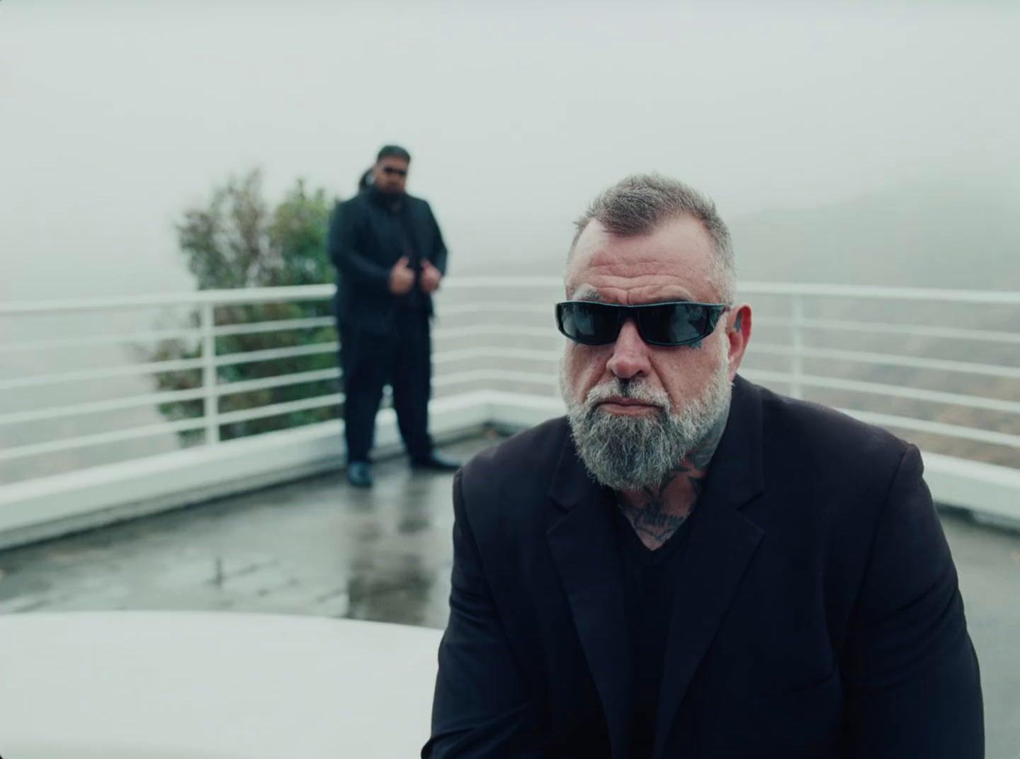 a man with a beard wearing sunglasses on a boat