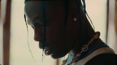 a man with dreadlocks is looking at his cell phone