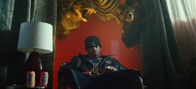 a man sitting in a chair next to a lamp