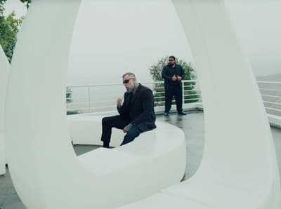 a man sitting on top of a white sculpture