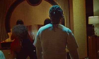 a woman with dreadlocks standing in front of a mirror