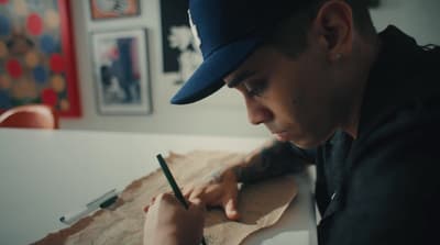 a man sitting at a table writing on a piece of paper