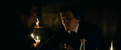 a man sitting at a table with a candle in front of him