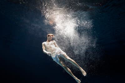 a man floating in the water with his shirt off