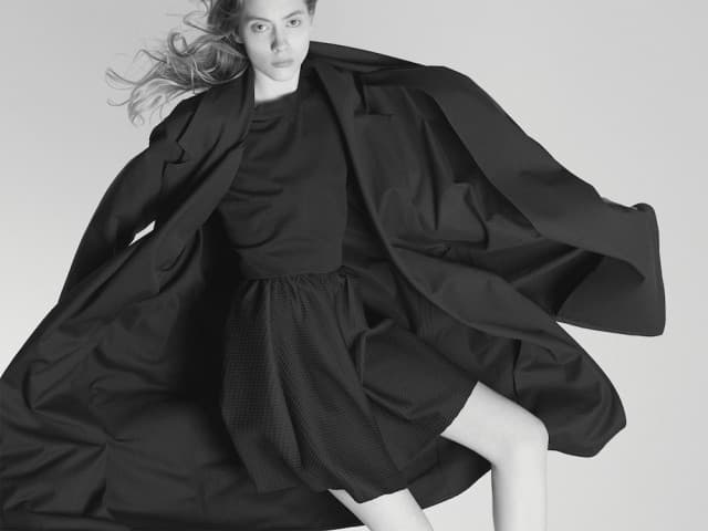 a woman is posing in a black dress