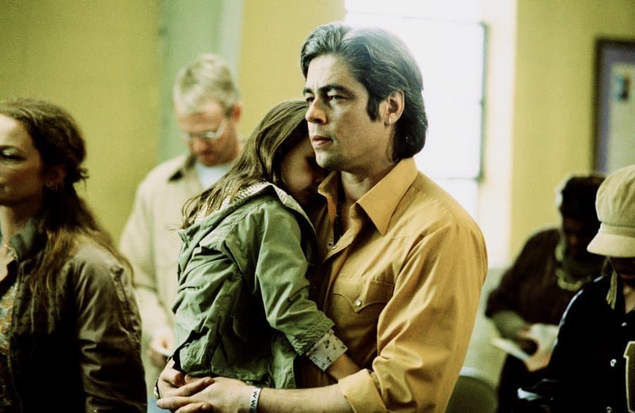 a man and a woman hug in a room full of people