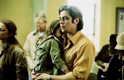 a man and a woman hug in a room full of people