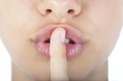 a woman making a hush with her finger