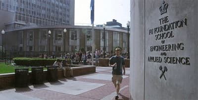 a man walking down a sidewalk next to a building