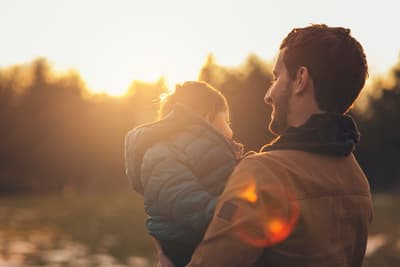 a man holding a little girl in his arms