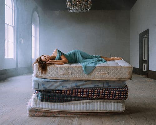 a woman laying on top of a mattress in a room