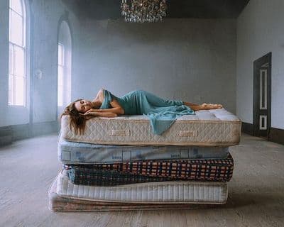 a woman laying on top of a mattress in a room