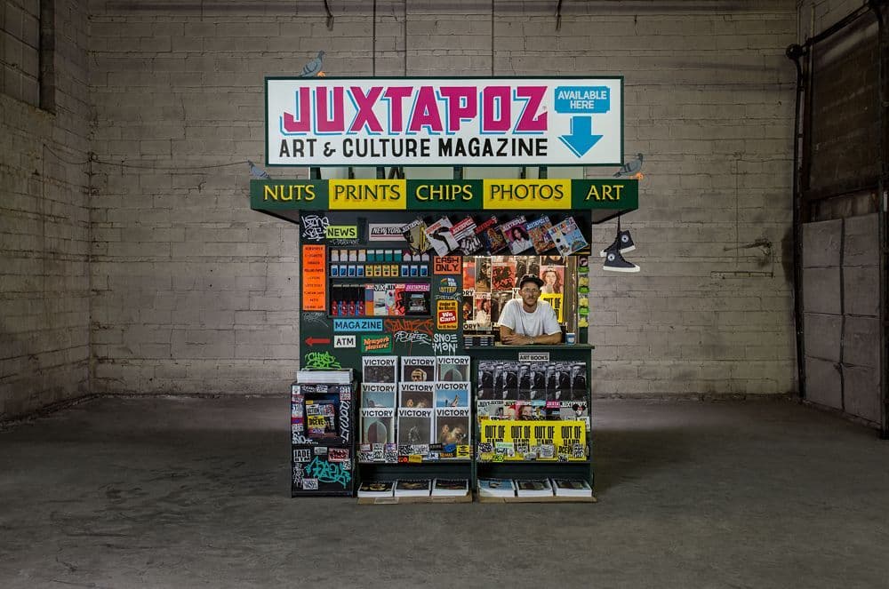 a magazine stand in a garage with a sign above it