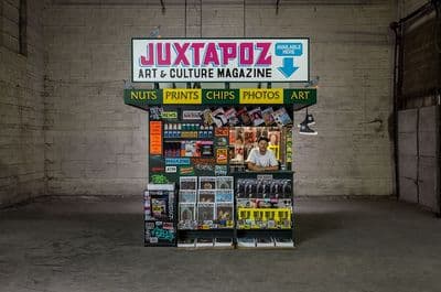 a magazine stand in a garage with a sign above it