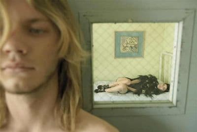 a woman laying on a bed in front of a mirror