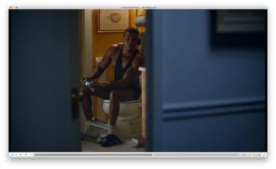 a man sitting on a toilet talking on a cell phone