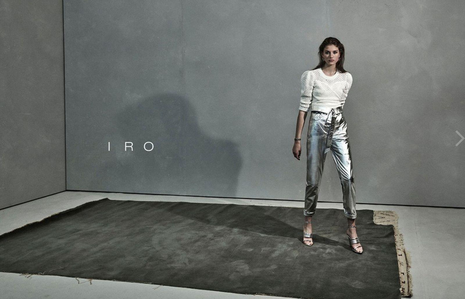 a woman standing in front of a gray wall