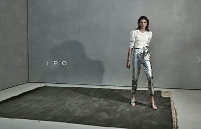 a woman standing in front of a gray wall