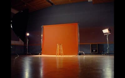 a photo studio with a large orange screen