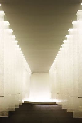 a long hallway with white columns and lights