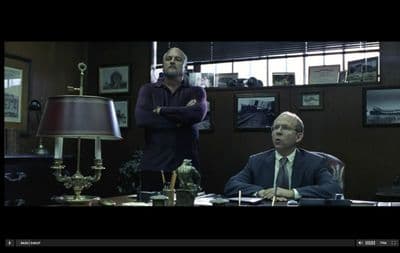 two men sitting at a table in a room