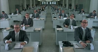 a group of men sitting at desks in a room