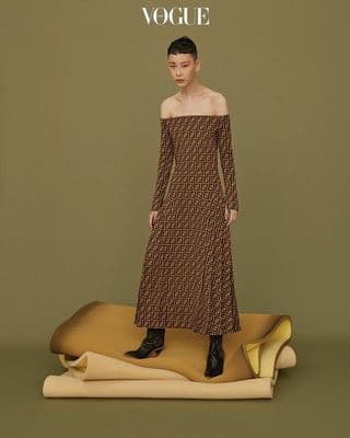 a woman in a brown dress standing on a mat