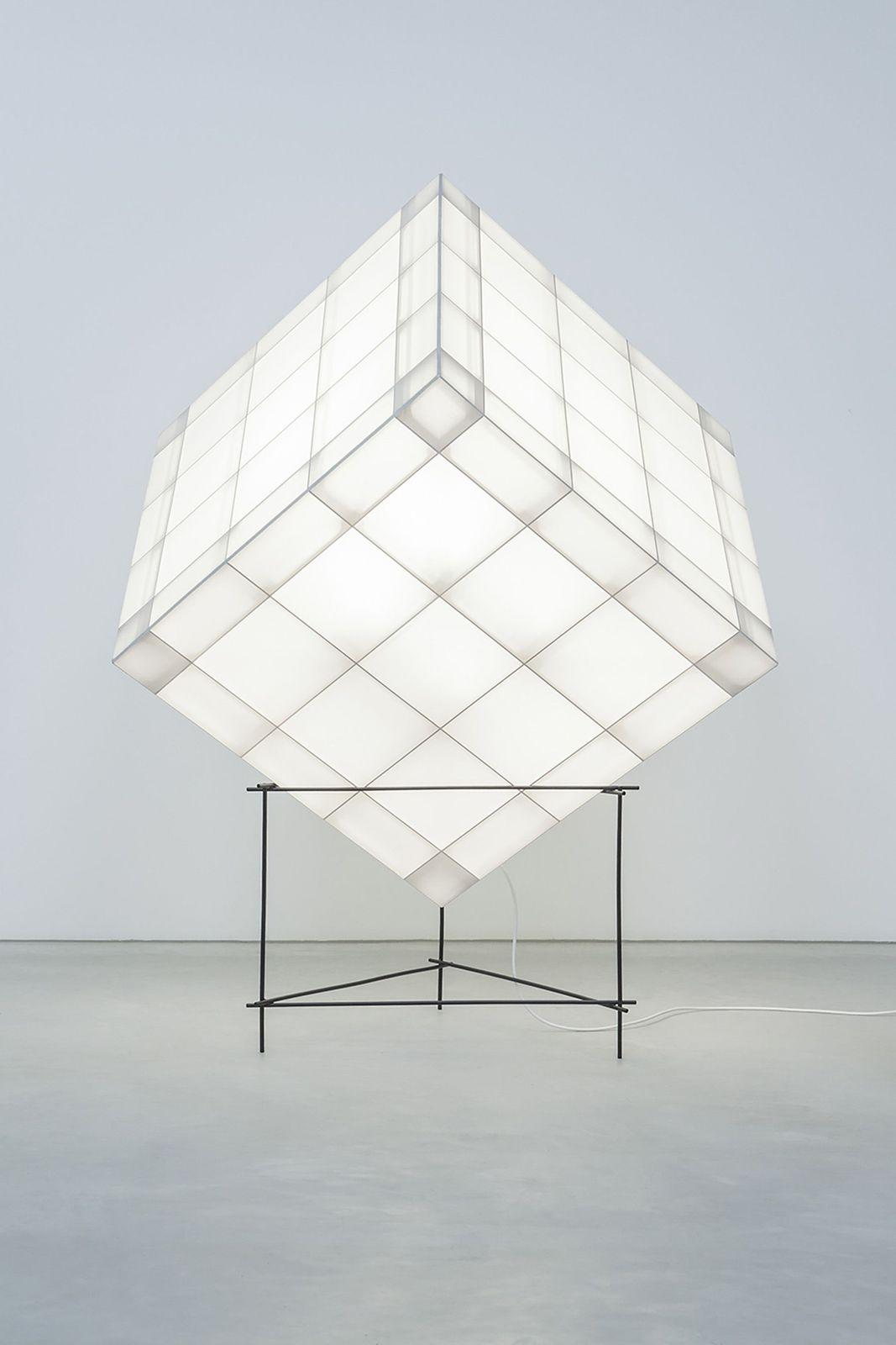 a large white cube sitting on top of a metal stand