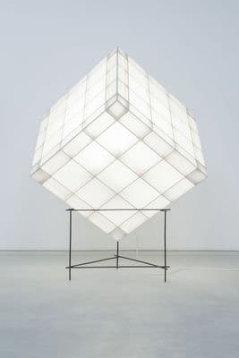 a large white cube sitting on top of a metal stand