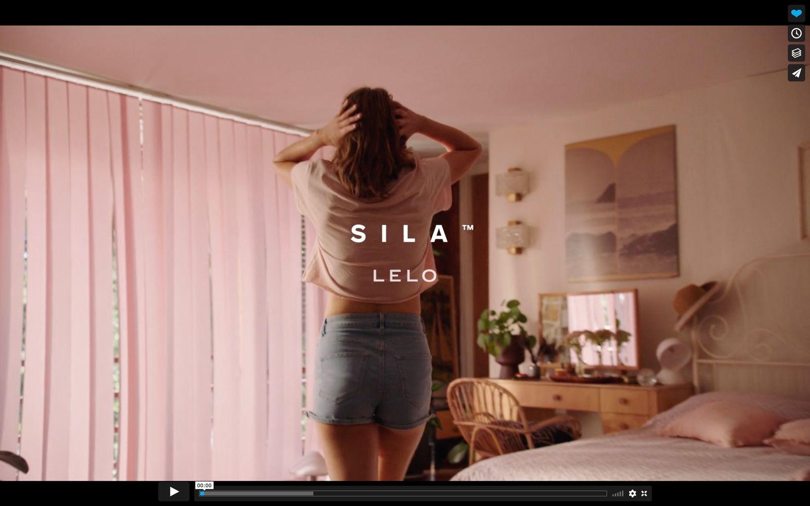 a woman standing in front of a bed in a bedroom