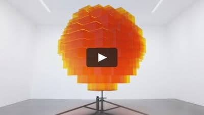 a video of a large orange object in a white room