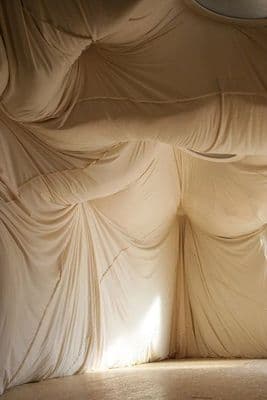 a room with a white curtain covering the walls