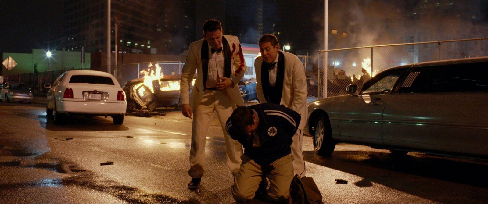 a couple of men standing next to each other on a street